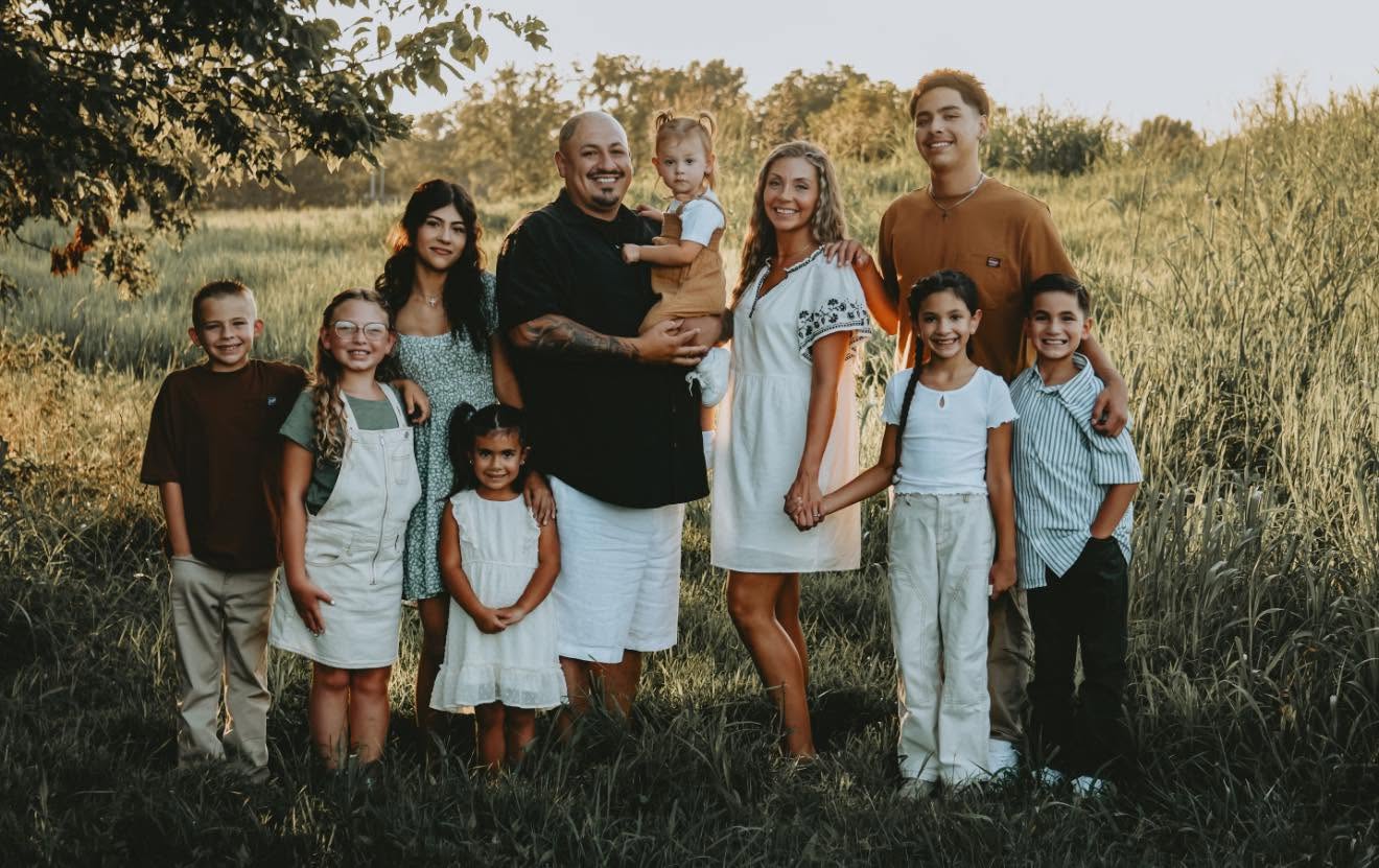Victor Loza and his family in a field at sunset
